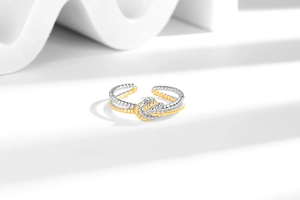 Close-up of two-tone twisted knot ring featuring gold and silver braided metal textures