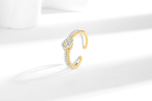 Macro shot of two-tone twisted rope knot ring featuring gold and silver woven texture