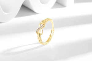 Detailed macro view of a gold infinity ring with micro-set zircons and a textured band