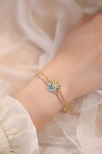 Detail of layered sun and moon bracelet featuring zircon inlays on a model wrist