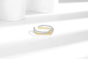 Detail of two-tone twisted knot ring featuring gold and silver interwoven rope texture