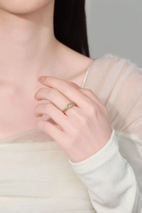 Detail shot of a two-tone twisted ring in gold and silver finish on a female finger