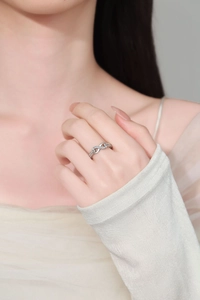 Close-up of infinity ring with pave-set crystals and twisted band on finger