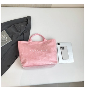 Détail du sac cabas rose en Tyvek avec finition brillante et imprimé TOTE BAG