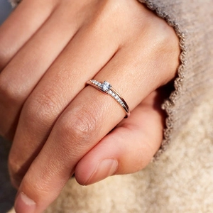 Elegant rose gold diamond ring featuring a round center stone and pave-set band on finger