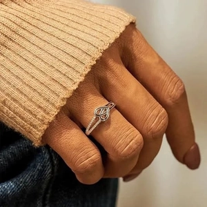 Gros plan détaillé d'une bague coeur en argent avec des zircons portés sur la main
