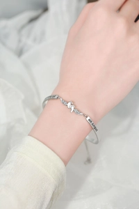 Detailaufnahme von Silberarmband mit Engelsflügeln und Mommy of an Angel Gravur