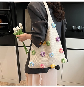 Détail d'un sac en tricot avec des fleurs colorées en relief et texture en coton