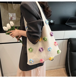 Détail de fleurs au crochet 3D colorées sur un sac en maille beige porté par un mannequin
