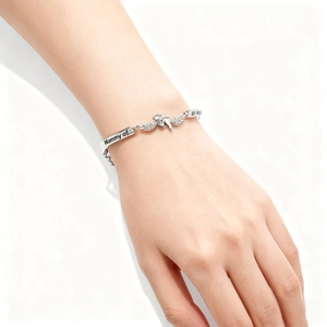 Detailaufnahme des silbernen Engelsflügel-Armbands mit Baby-Fußabdruck und Inschrift