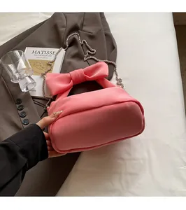 Pink bow handbag on blazer with detachable silver chain strap and puffy fabric detail