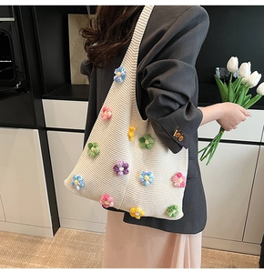 Détail d'un sac bandoulière en tricot crème avec fleurs en crochet 3D et texture douce