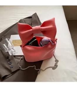 Interior view of pink bow handbag showing storage capacity for phone and umbrella