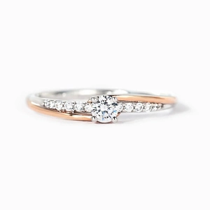 Elegant two-tone bypass ring with round center stone and diamond accents on a white background