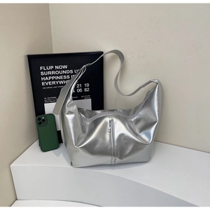 Détail du sac hobo argenté métallisé montrant la texture brillante et le zip décoratif