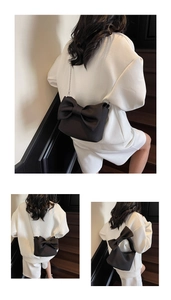 Detail of black bow crossbody bag with silver metal chain on matte nylon material