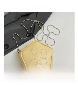 Detailed view of yellow star-shaped mini crossbody bag with sleek silver chain strap