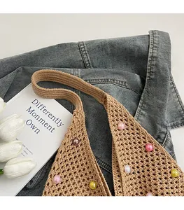 Close-up of knit tote bag with colorful beads, wide shoulder strap and mesh texture