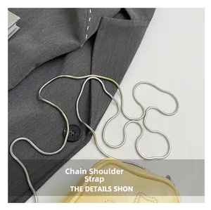 Macro shot of silver metal chain strap on a yellow lychee pattern leather handbag