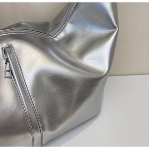 Détail de la texture cuir argenté métallisé et fermeture éclair de ce sac à bandoulière