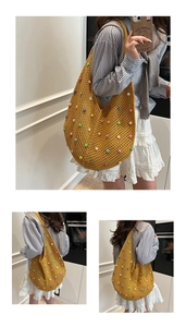 Detail of hand-crocheted yellow beach bag with colorful beads and pearl accents