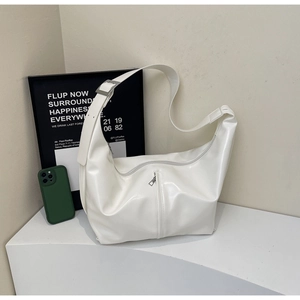 Détail du sac hobo en cuir verni blanc avec fermeture éclair et bandoulière argent
