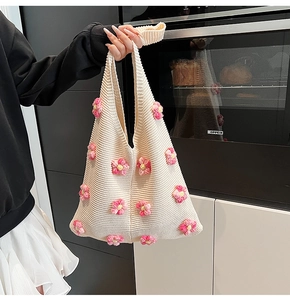 Gros plan du sac bandoulière en tricot crème avec décorations de fleurs 3D roses