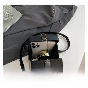 Detail showing internal capacity of the snake pattern box bag with phone and cosmetics