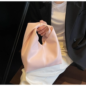 Detail of light pink tote bag featuring unique knotted handle design and premium faux leather