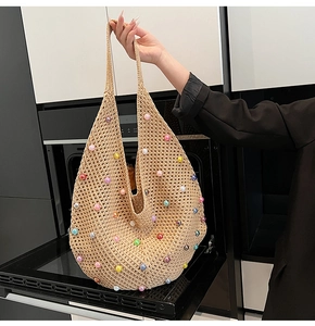 Detailed view of handmade beige crochet tote bag with colorful beads and boho texture