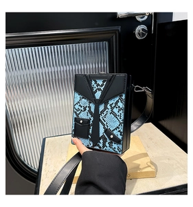 Detail of blue python pattern box bag with creative tuxedo suit design and silver buckles