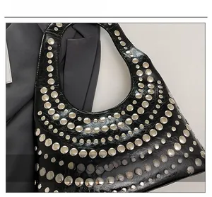 Detailed close-up of punk-style shoulder bag featuring metallic rivet stud embellishments