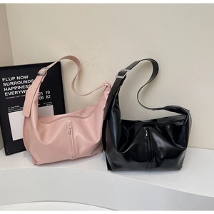 Détail du sac hobo en cuir brillant avec large bandoulière et boucle en métal argenté