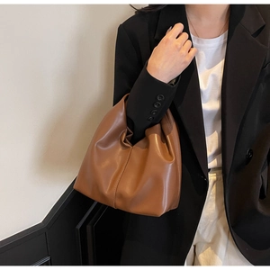Detailed view of the soft brown pleated cloud bag featuring premium leather texture