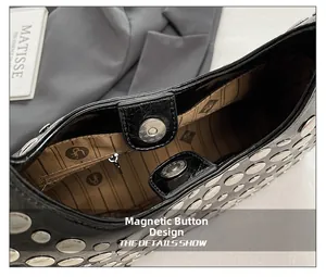 Detailed shot of magnetic closure and rivet accents on black punk style shoulder bag