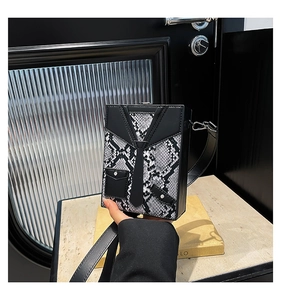 Detailed close-up of a snake-skin pattern box bag with creative tuxedo design details
