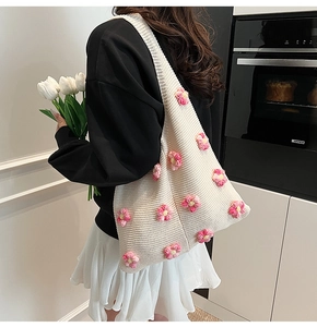 Détail d'un sac à bandoulière en crochet avec des fleurs roses en tricot 3D faites main