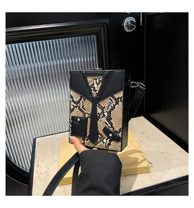 Close-up of snakeskin texture box bag featuring a unique tuxedo suit-inspired design