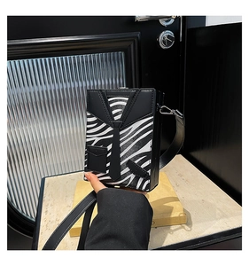 Detail of hardshell messenger bag featuring a zebra print suit design and black tie