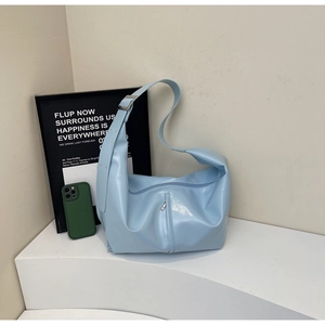 Détail d'un sac à bandoulière bleu clair en similicuir brillant avec boucle argentée