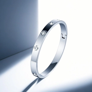 Detailed view of silver bangle with embossed rose floral patterns and snap closure