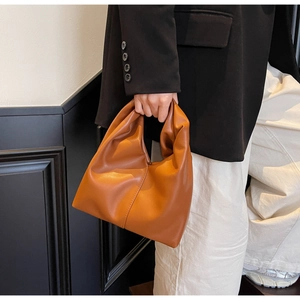 Detail shot of brown pleated cloud handbag in matte leather finish for daily commuting
