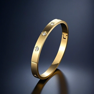 Detail of gold-plated titanium steel bangle featuring inset diamonds and a side hinge clasp