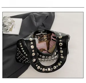 Detailed capacity view of black patent leather rivet handbag showing interior space