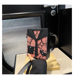 Detailed view of pink and black snake print box bag with suit jacket design detail