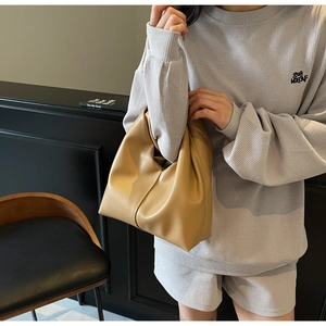 Detail of the khaki slouchy cloud bag featuring pleated faux leather and soft handle