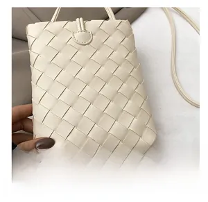 Detail shot of beige woven leather phone bag texture with premium craftsmanship