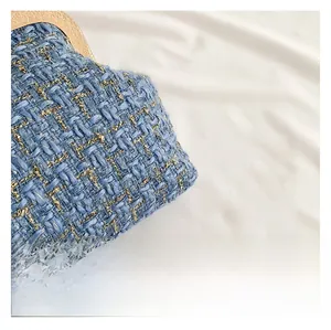 Detail of blue and gold tweed evening bag showing vintage engraved gold metal clasp