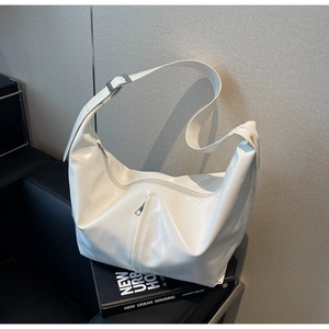 Détail du sac hobo en similicuir blanc brillant avec boucle réglable et fermetures éclair