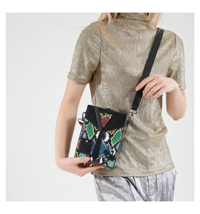 Detail view of colorful snake skin hard case messenger bag with suit tie design